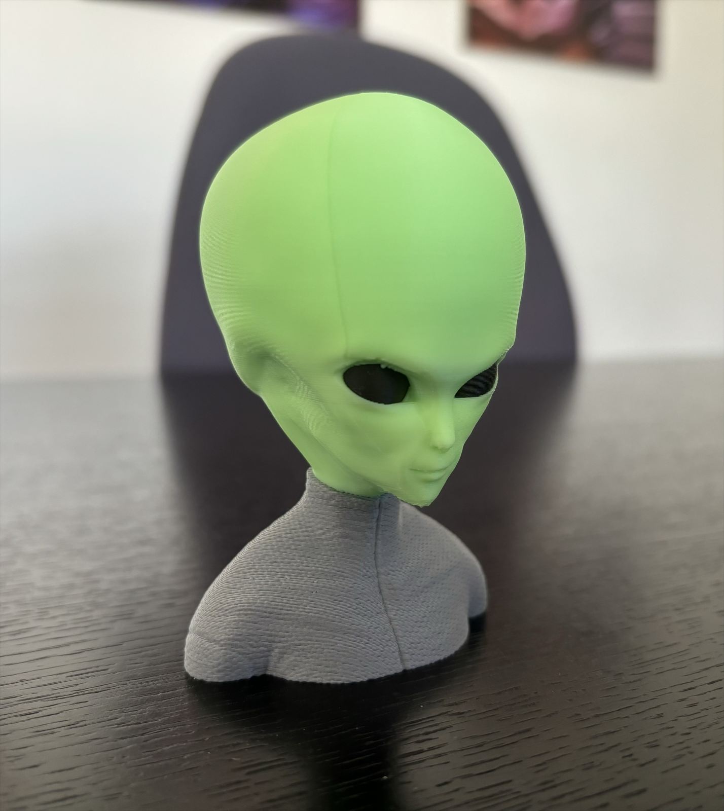 Green alien bust on a grey base